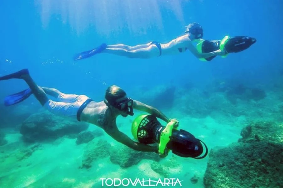 Couple diving underwater using sea scooters in Puerto Vallarta.