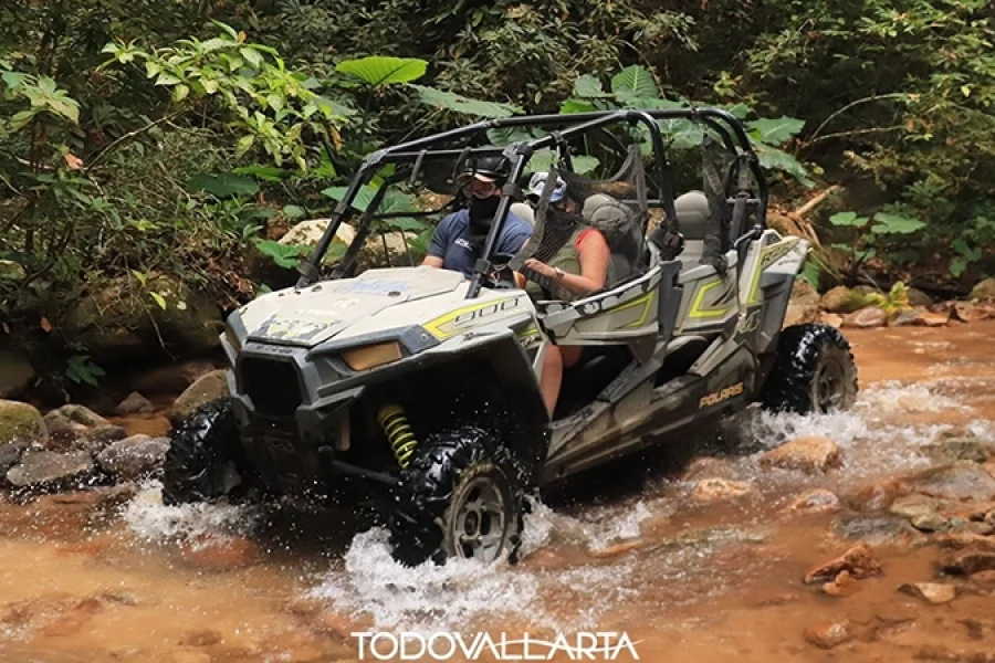 Two riders navigating river rocks