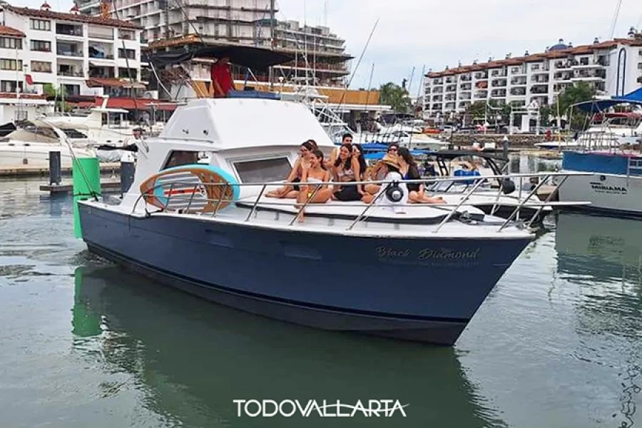 Front view of Vallarta boat rental Black Diamond with guests sunbathing on the bow