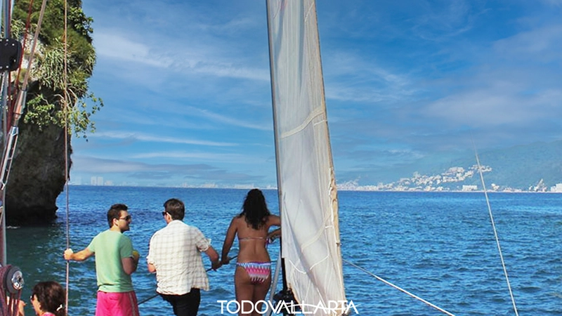 Guests on the foredeck of Ally Cat gazing across Banderas Bay toward Puerto Vallarta’s skyline on catamaran charter 56.