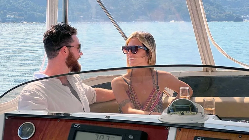 A couple enjoying the front seating area of the yacht, sharing a peaceful moment on the water.