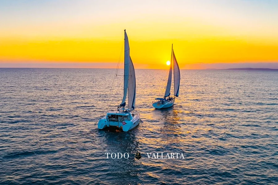 Two sailboats gracefully cruising side by side at sunset near Puerto Vallarta