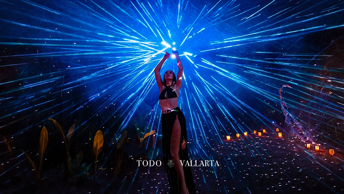 A dancer illuminated by vibrant laser lights at Majahuitas Beach Party's nighttime event.