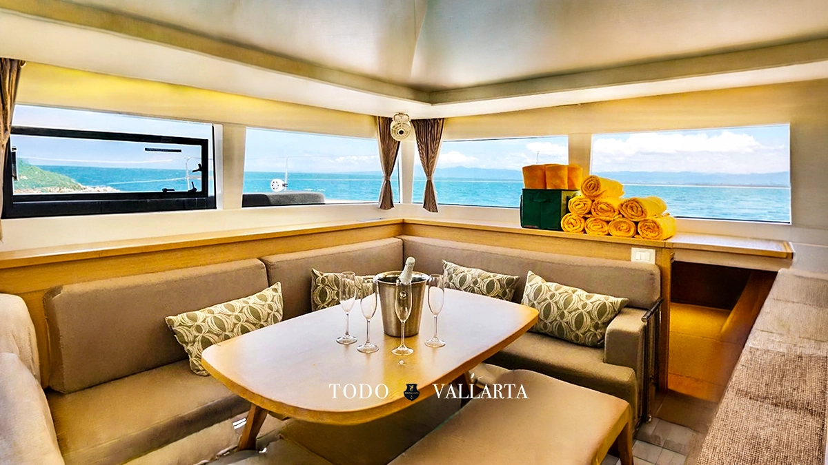 catamaran charter lagoon 45 interior salon with dining table, champagne bucket, and ocean vistas