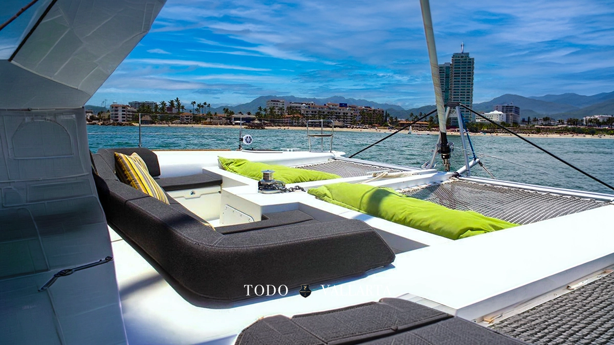 catamaran charter lagoon 45 forward deck lounge with black cushioned seating and city skyline view