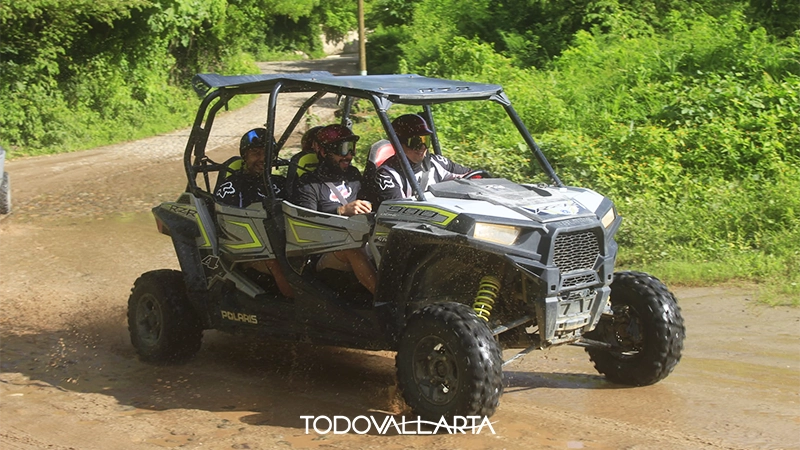Four-person RZR splashing through a muddy water trail in Puerto Vallarta