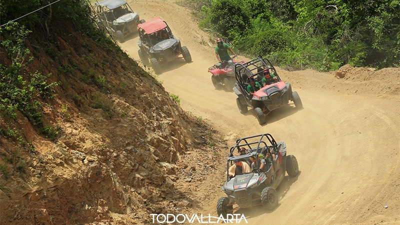 A fleet of RZRs descending a winding dirt trail in the Sierra Madre