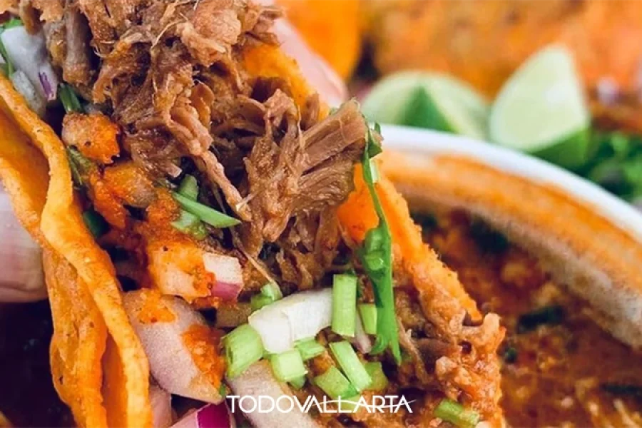 Close-up of a birria taco dipped in consommé during a taco tour in Versalles