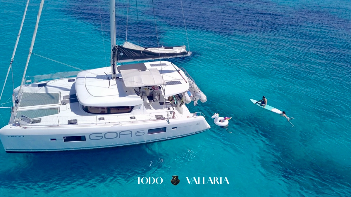 charter goa - 42Ft luxury catamaran aerial side view with paddleboard and unicorn float in clear bay waters