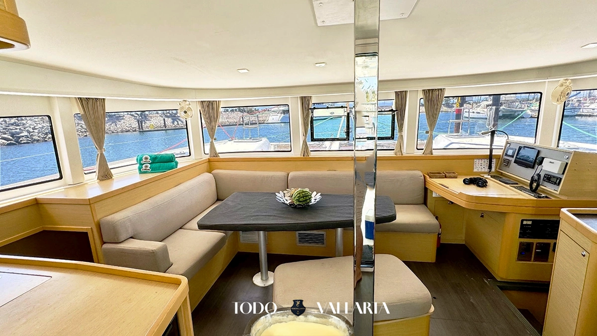 charter goa - 42Ft luxury catamaran interior salon with beige seating, wood accents, and navigation station