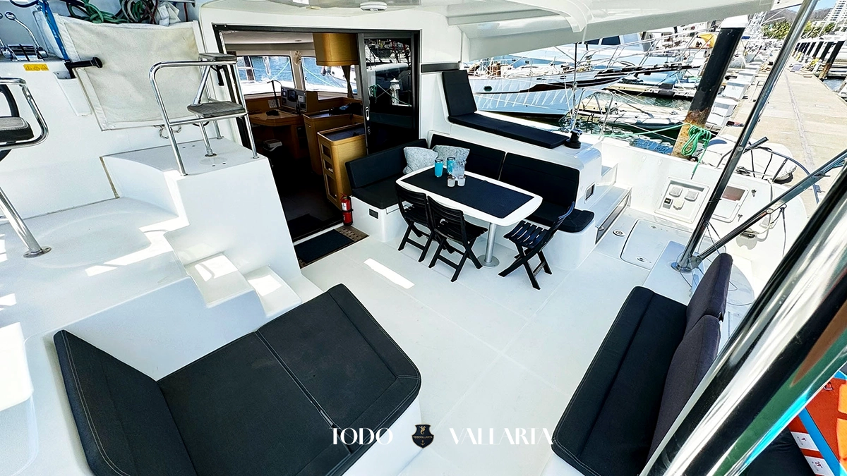 charter goa - 42Ft luxury catamaran aft deck with black cushioned seating, dining table, and panoramic ocean views
